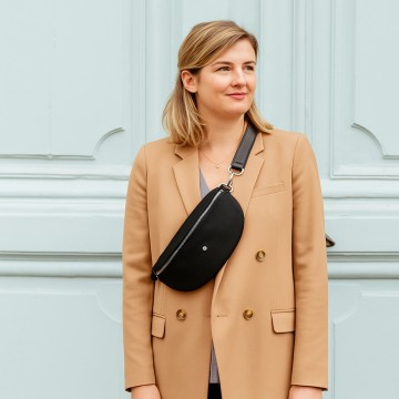 Sac banane noir porté en bandoulière pour une allure urbaine et élégante.